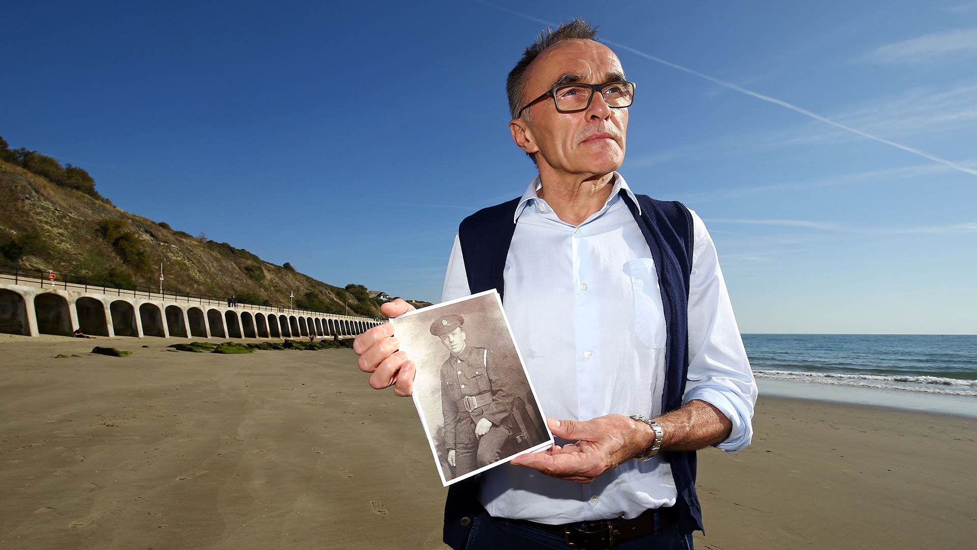 Danny Boyle holding a photograph of a soldier