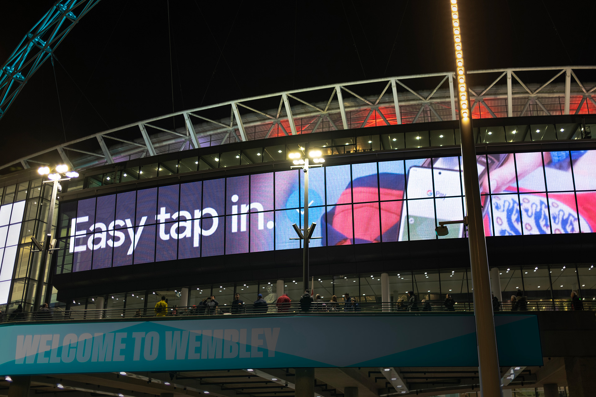 Outdoor screen at Wembley Stadium displaying a GPay advert